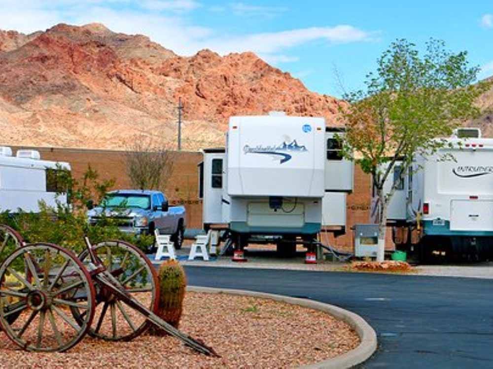 A view of RV sites with mountains in the background at CANYON TRAIL RV PARK