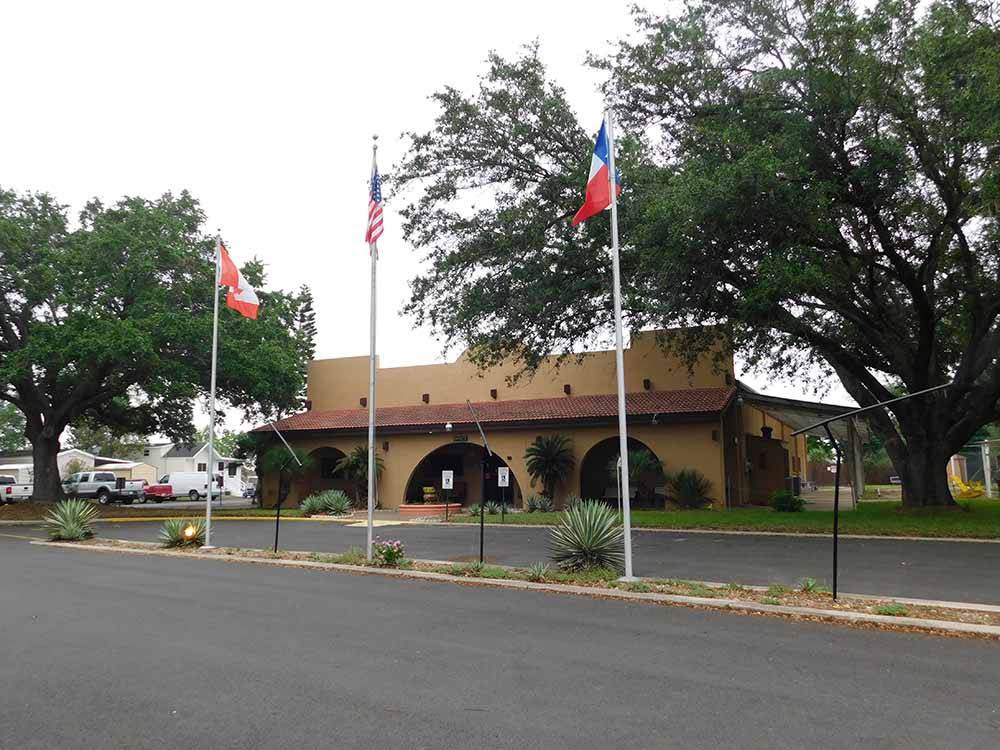 The front of the office building with three flags at FIG TREE RV RESORT