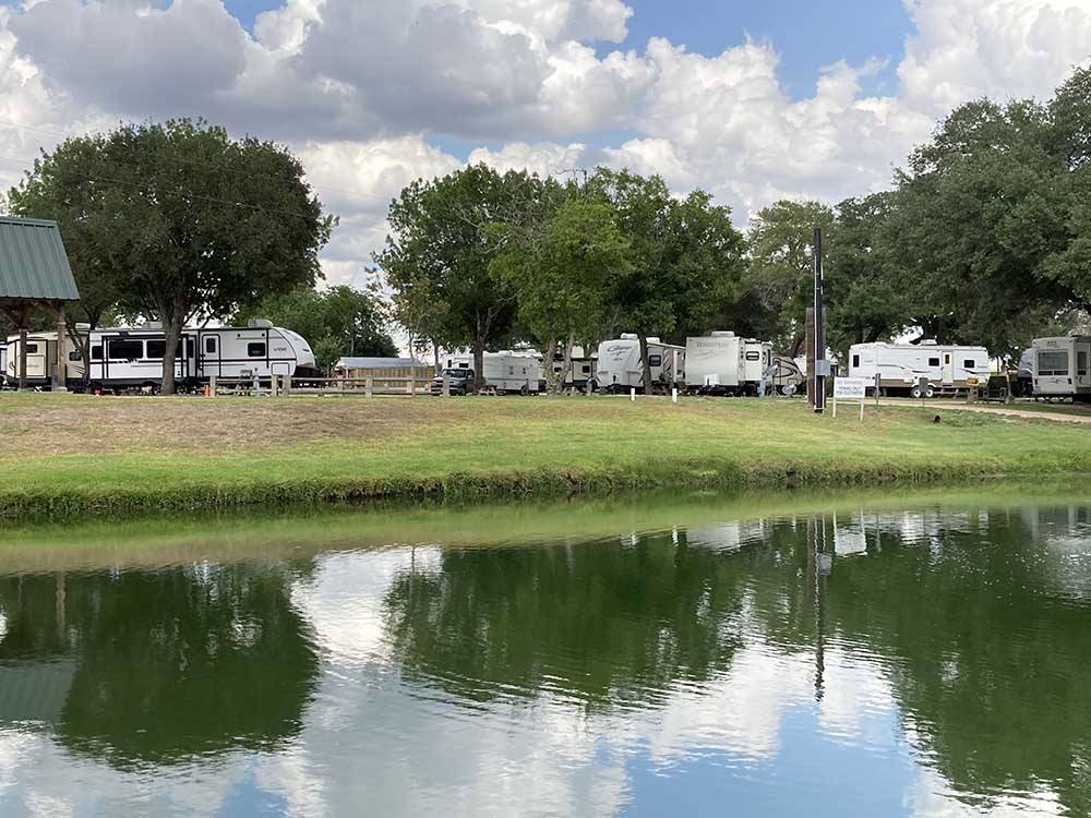 RVs parked with a lake view at SCHULENBURG RV PARK