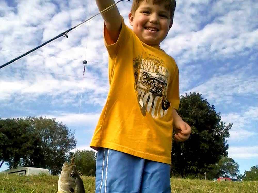 A little boy showing off the fish he caught at SCHULENBURG RV PARK