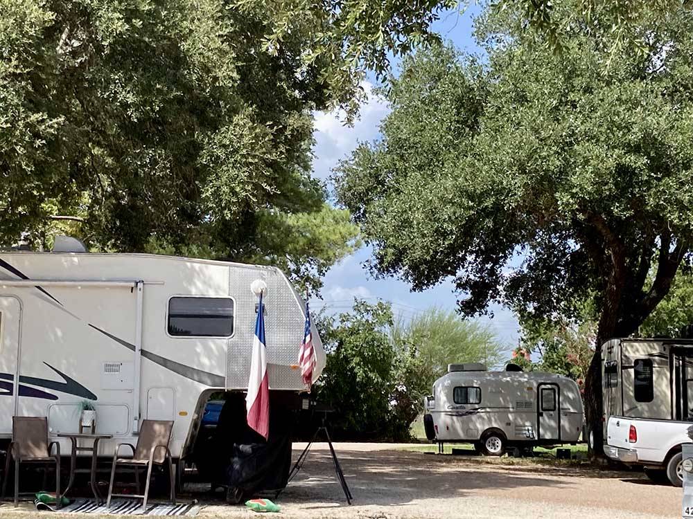 A fifth wheel trailer with flags on it at SCHULENBURG RV PARK