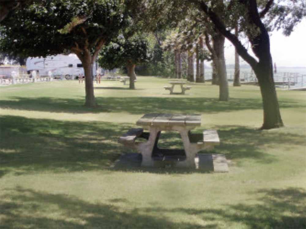 A line of picnic benches by the water at DUCK ISLAND RV PARK & FISHING RESORT