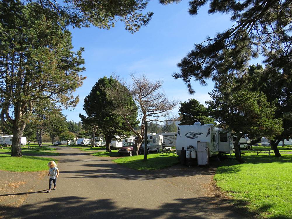 A child walks along a road leading into an RV campground at CIRCLE CREEK RV RESORT