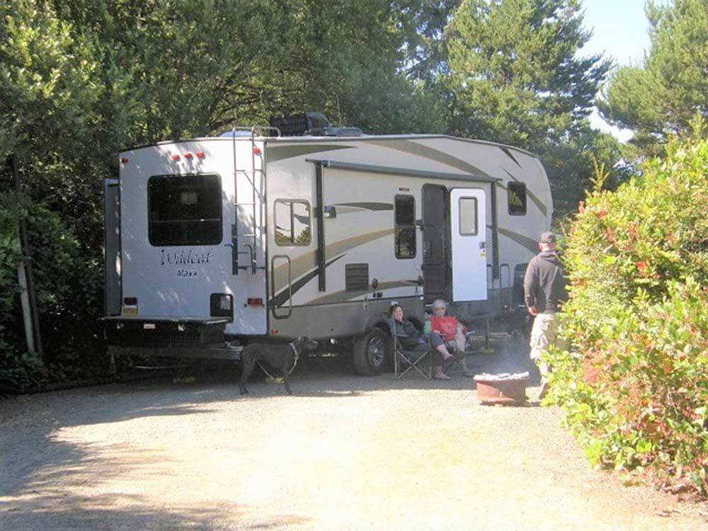 Trailer camping with elderly people outside at HECETA BEACH RV PARK