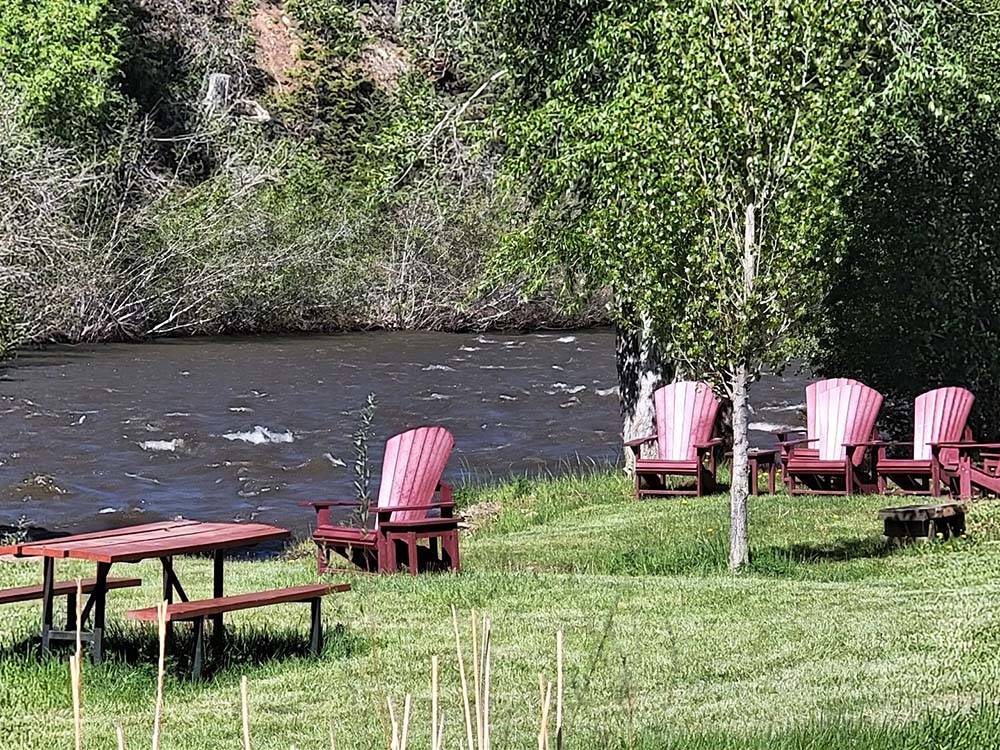 Picnic bench and chairs by the river at DOLORES RIVER RV RESORT BY RJOURNEY