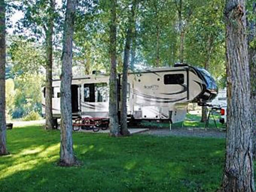 Fifth wheel and truck parked in gravel site at DOLORES RIVER RV RESORT BY RJOURNEY