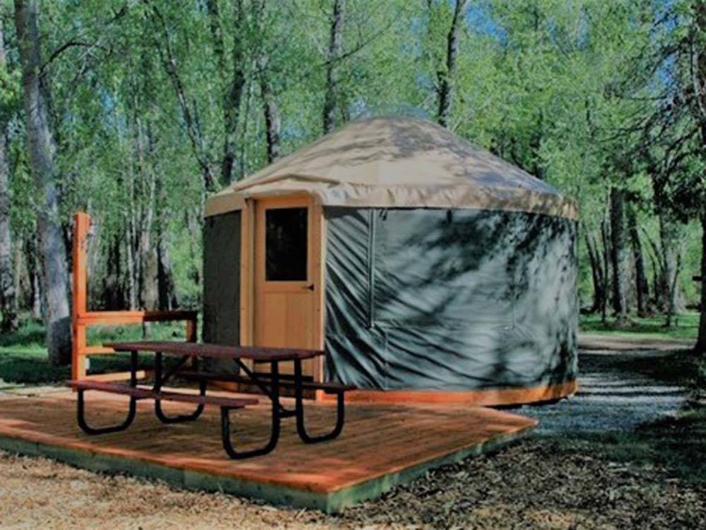 A yurt rental with a picnic bench at DOLORES RIVER RV RESORT BY RJOURNEY