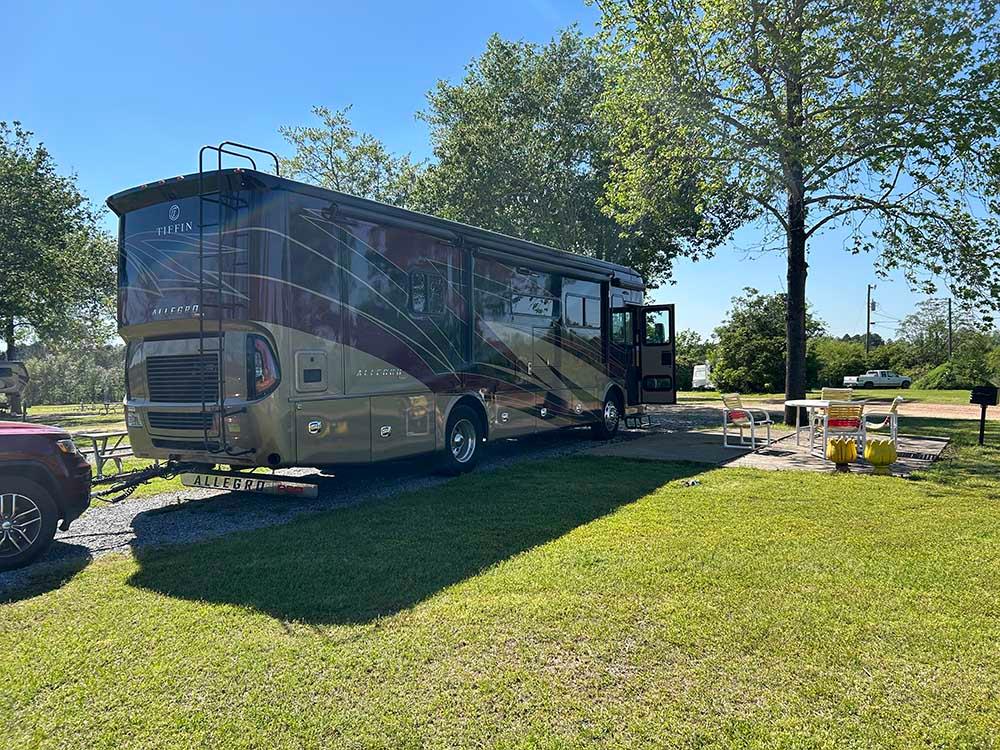 A Class A motorhome parked in a gravel site at TIFTON RV PARK I-75 (FORMERLY TIFTON KOA)