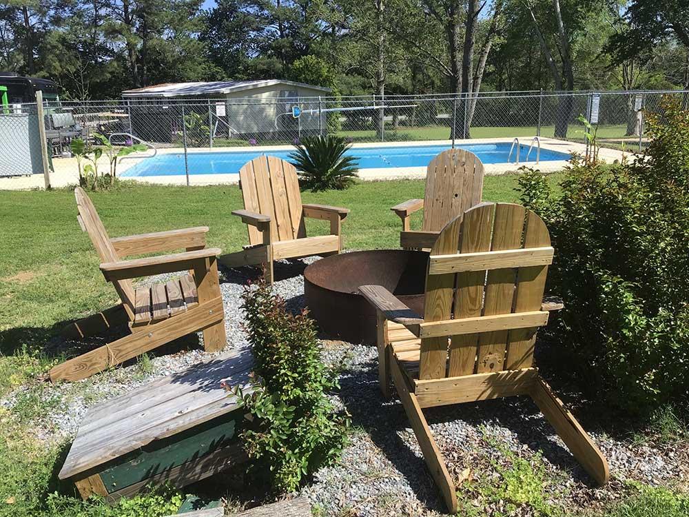 Chairs and fire pit next to the swimming pool at TIFTON RV PARK I-75 (FORMERLY TIFTON KOA)
