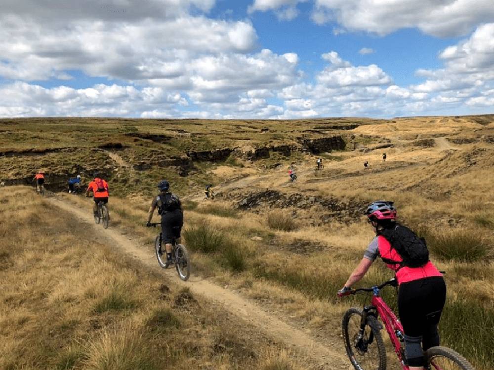 Bicycle riders riding the bike hill trails nearby