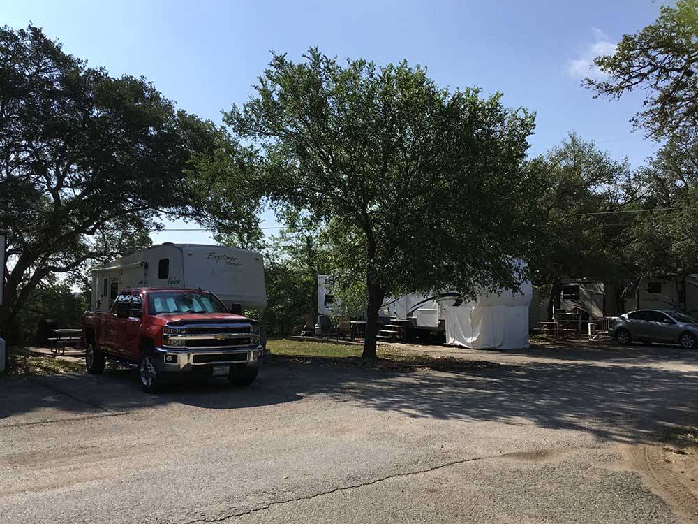 A truck and fifth wheel trailer in a RV site at TEXAS 281 RV PARK