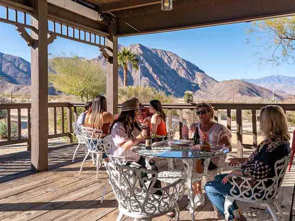 People sitting at tables on the patio at PALM CANYON HOTEL AND RV RESORT