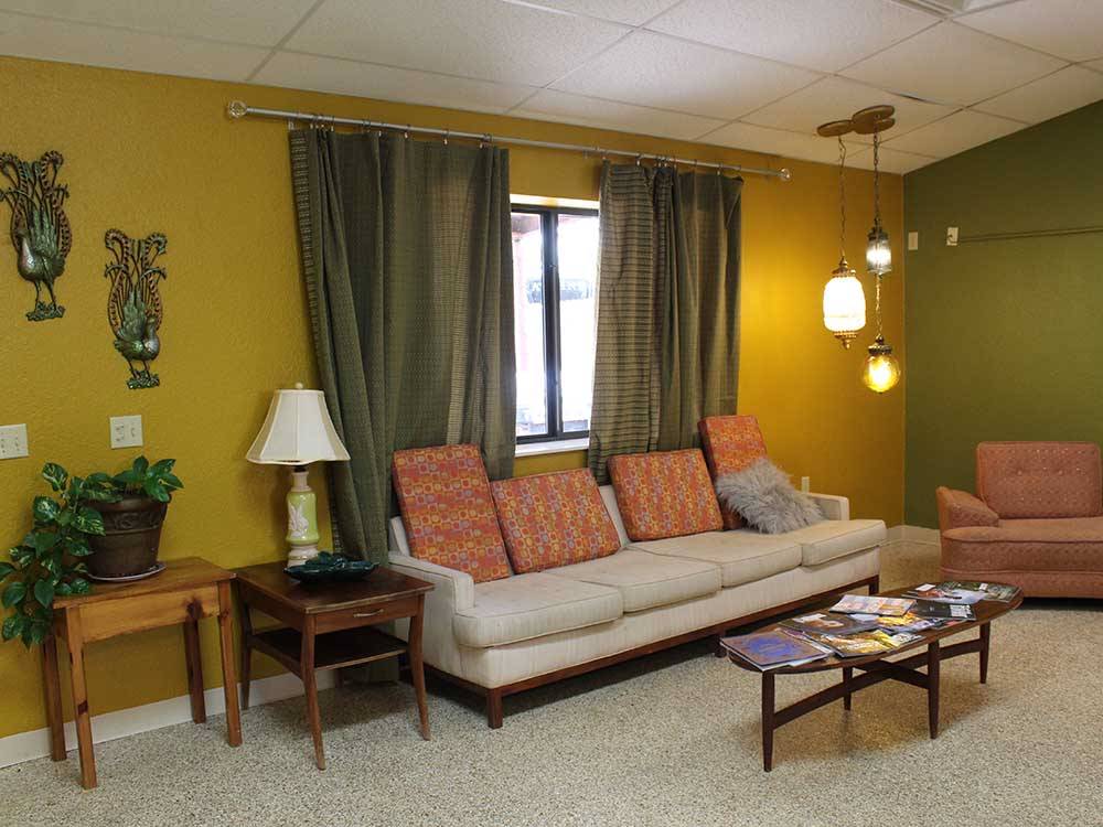 A lounge area with sofas, hanging lights and coffee table with magazines at ELK CREEK RV PARK
