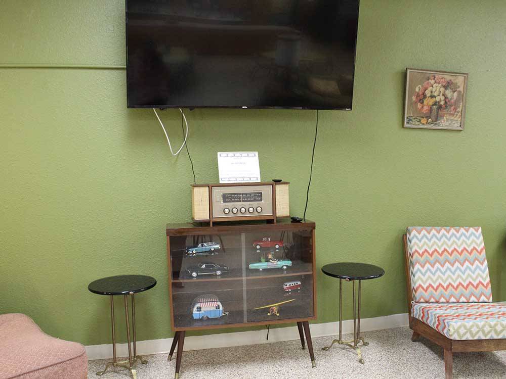 A big-screen TV hanging over a display cabinet with toy vehicles at ELK CREEK RV PARK