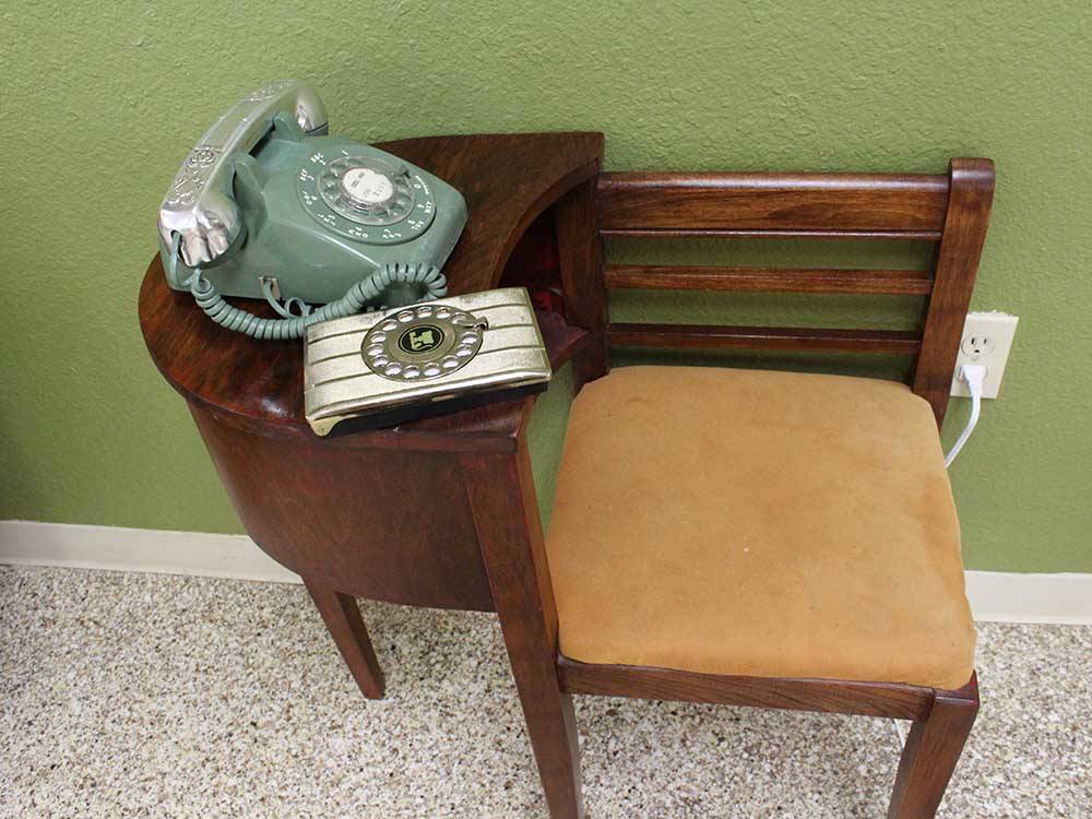 An old-fashioned phone on an antique table attached to a chair at ELK CREEK RV PARK