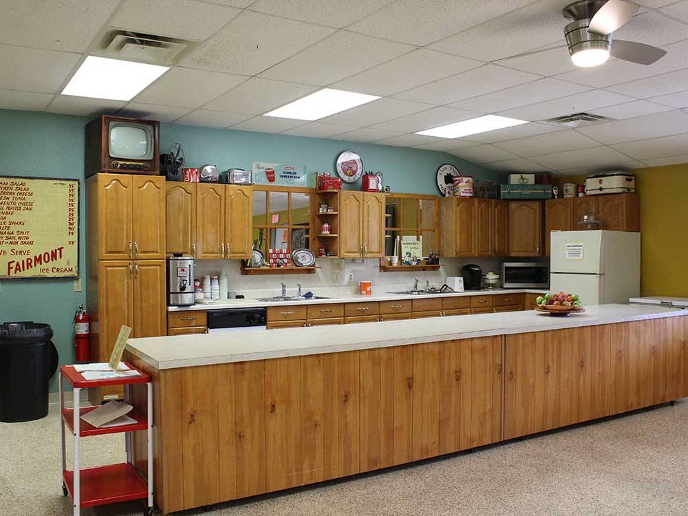 A long kitchen counter with fridge and cabinets at ELK CREEK RV PARK