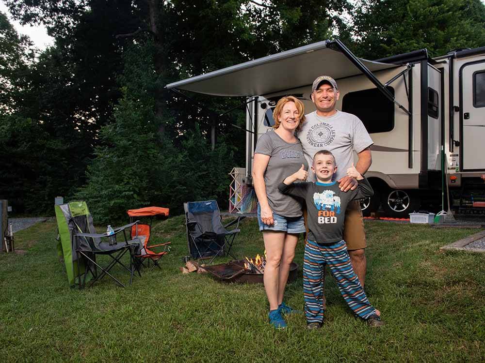 A family standing outside of their trailer at CHERRY HILL PARK
