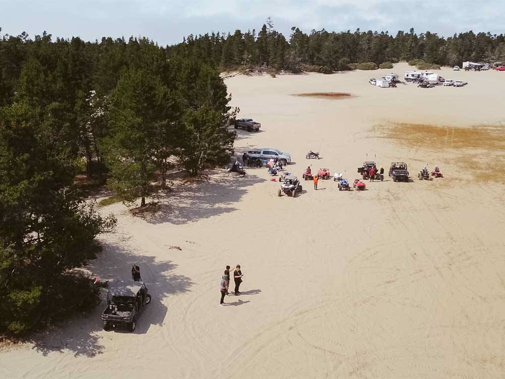 People sitting on the sandy beach nearby at LUCKY LOGGERS RV PARK
