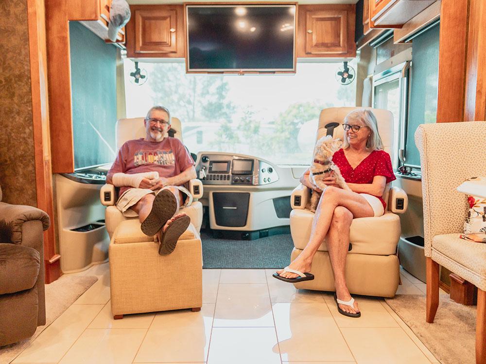 A couple and their dog sitting inside their motorhome at ESCONDIDO RV RESORT