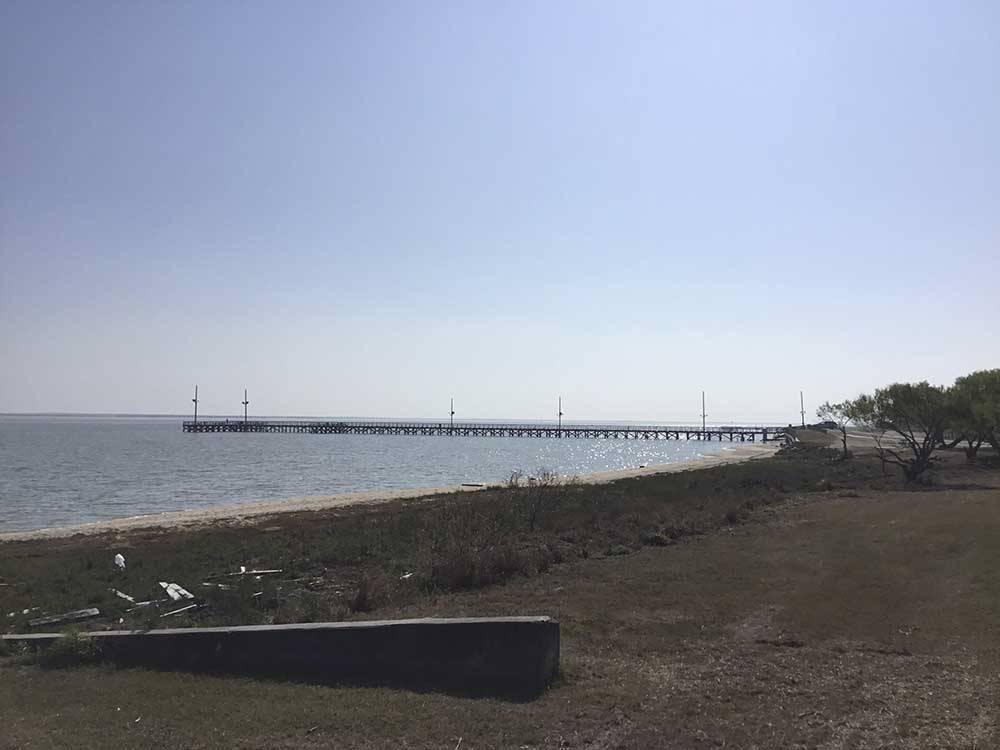 The beach with a pier at SEAWIND RV RESORT ON THE BAY
