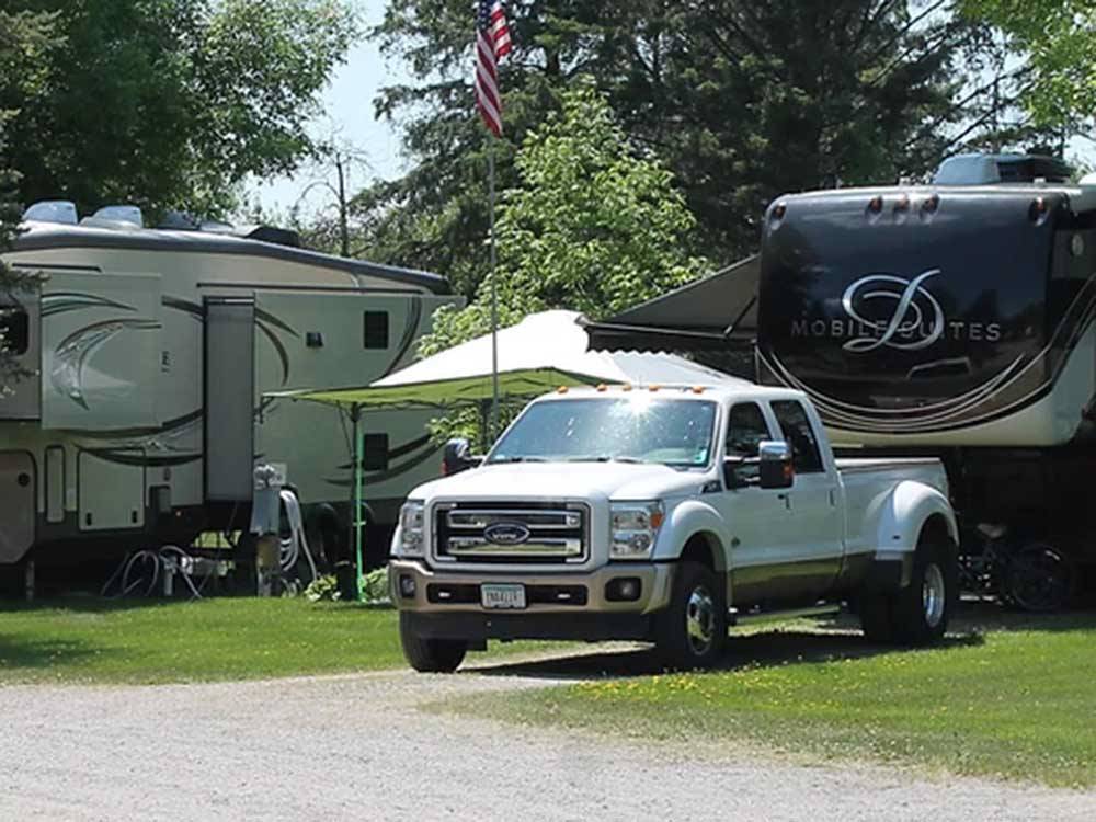 Fifth-wheel and pickup truck parked at campsite at ST CLOUD CAMPGROUND & RV PARK
