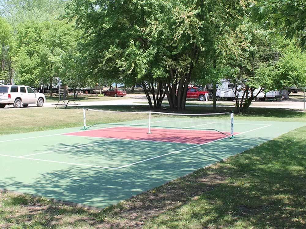 Pickleball court surrounded by lawn at ST CLOUD CAMPGROUND & RV PARK