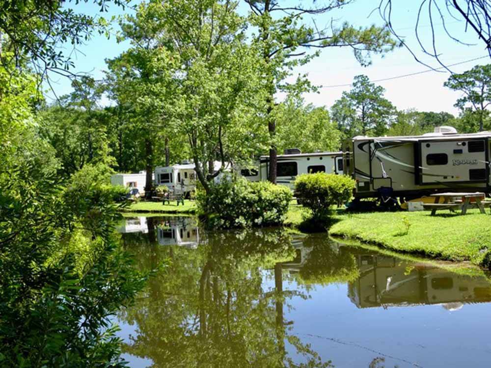 RVs parked in sites by the water at LAKE AIRE RV PARK & CAMPGROUND