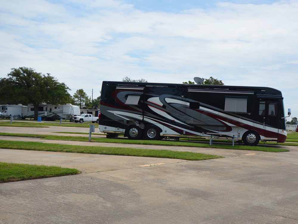 A motorhome in a paved pull thru site at TRADERS VILLAGE RV PARK
