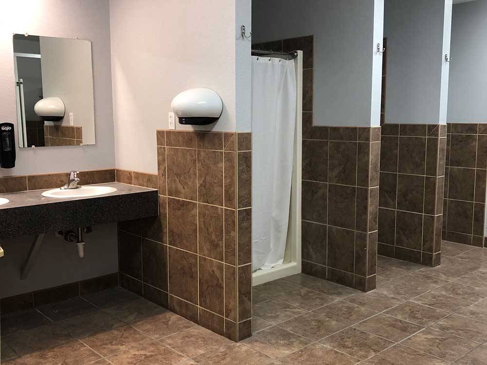 The clean bathroom and shower stalls at COWBOY RV PARK