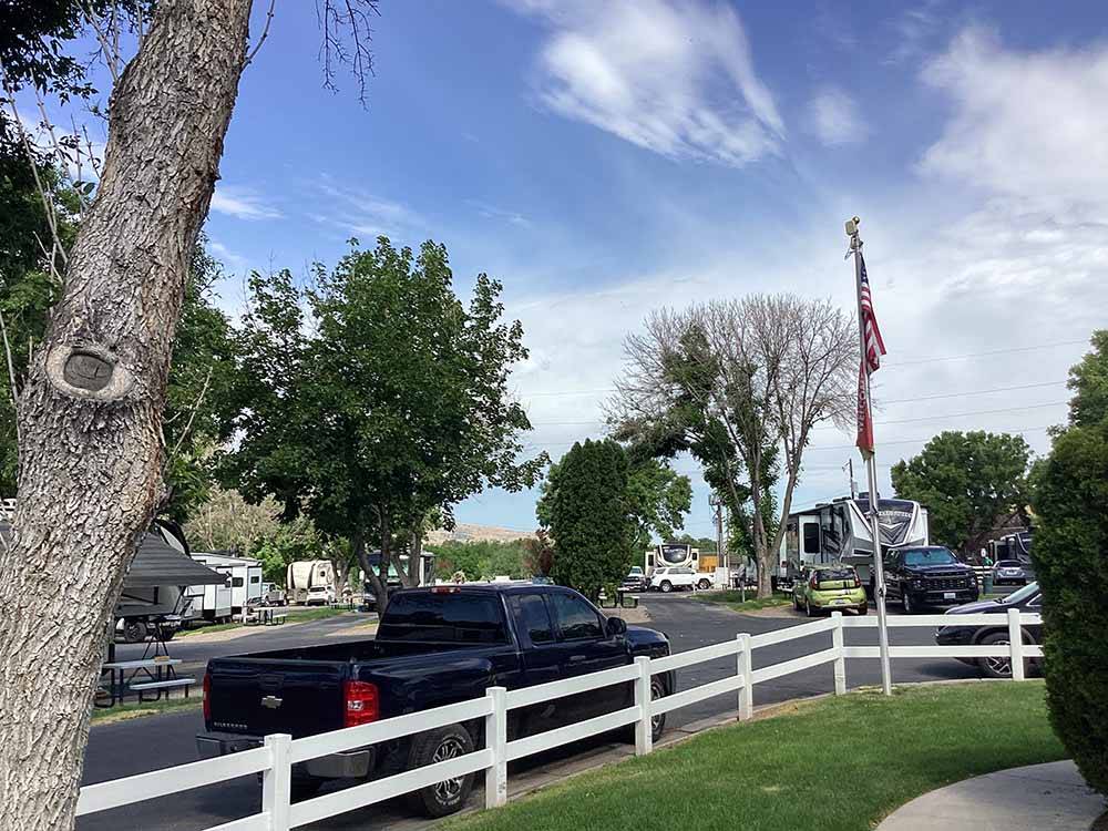 A black truck parked next to a white fence at COWBOY RV PARK