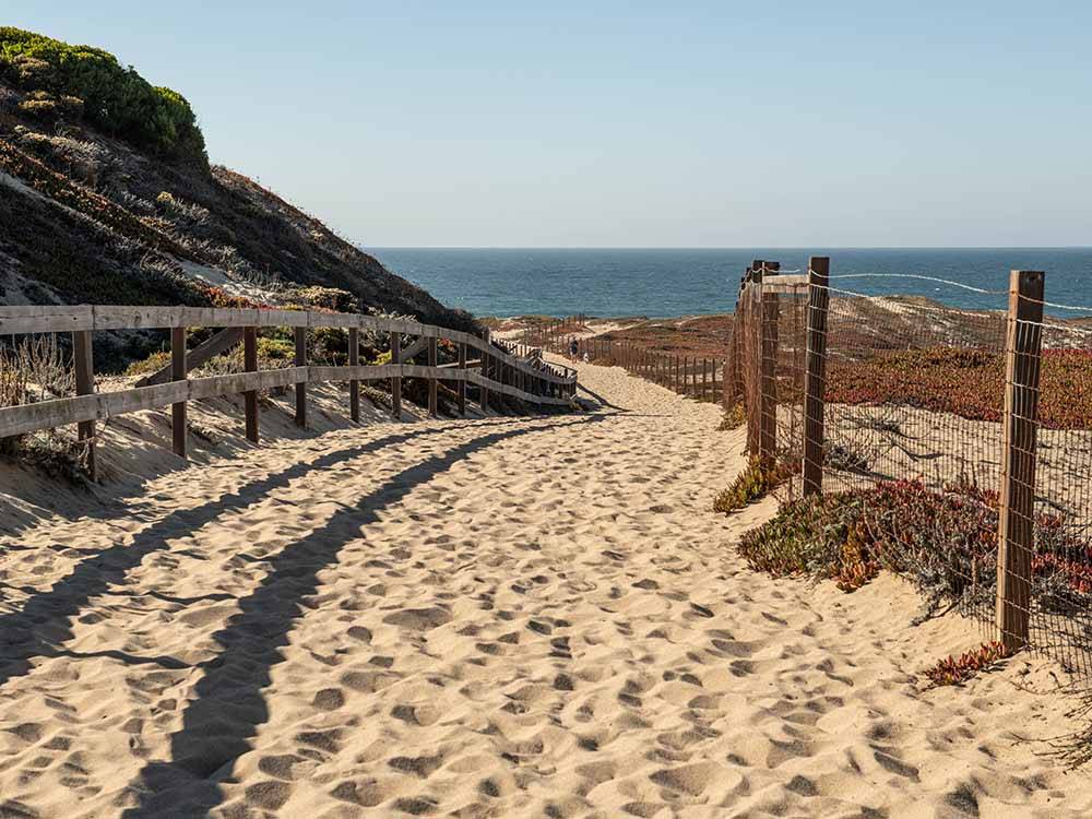 A sandy path leading to the beach at MARINA DUNES RV RESORT