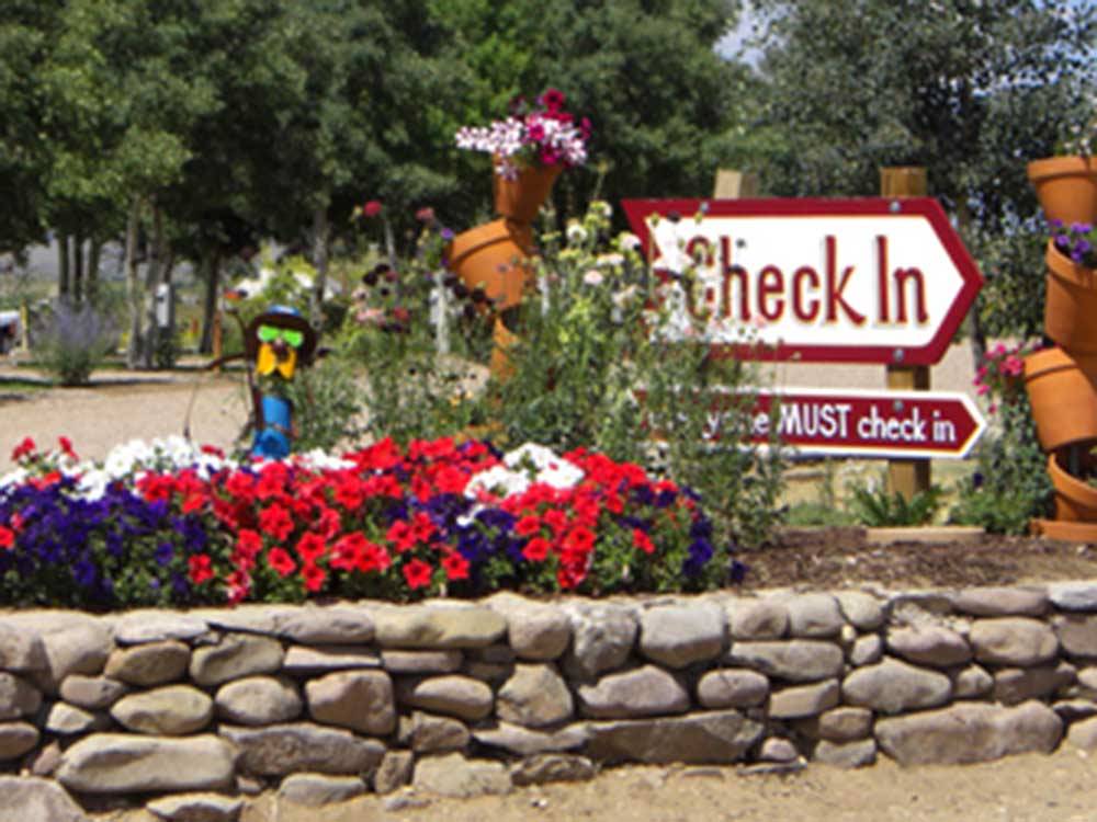 The check in sign with flowers at GRAPE CREEK RV PARK CAMPGROUND & CABINS