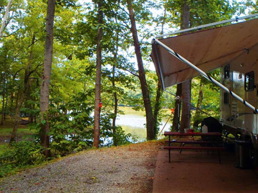 A trailer with an open awning overlooking the lake at SOARING EAGLE CAMPGROUND & RV PARK