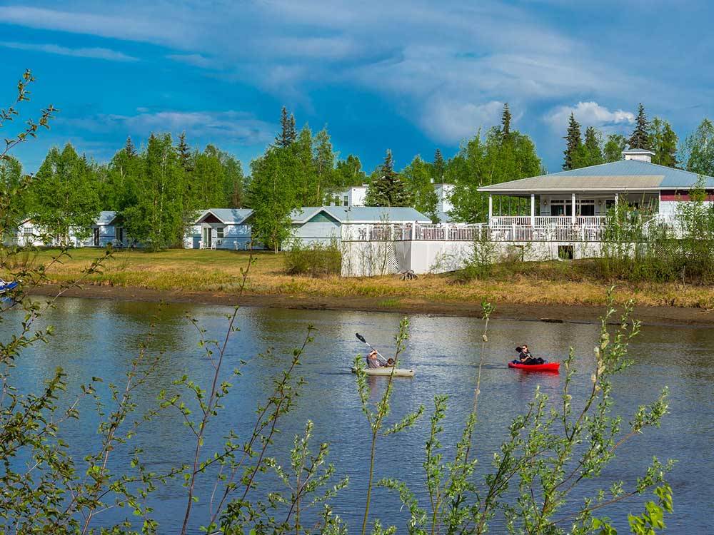 Water with kayakers and campground at RIVER'S EDGE RV PARK & CAMPGROUND
