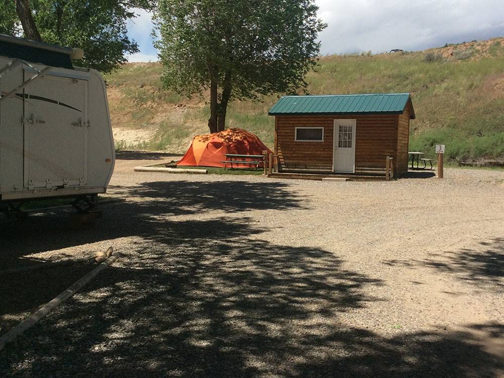 A tent pitched up next to a cabin at EAGLE RV PARK & CAMPGROUND