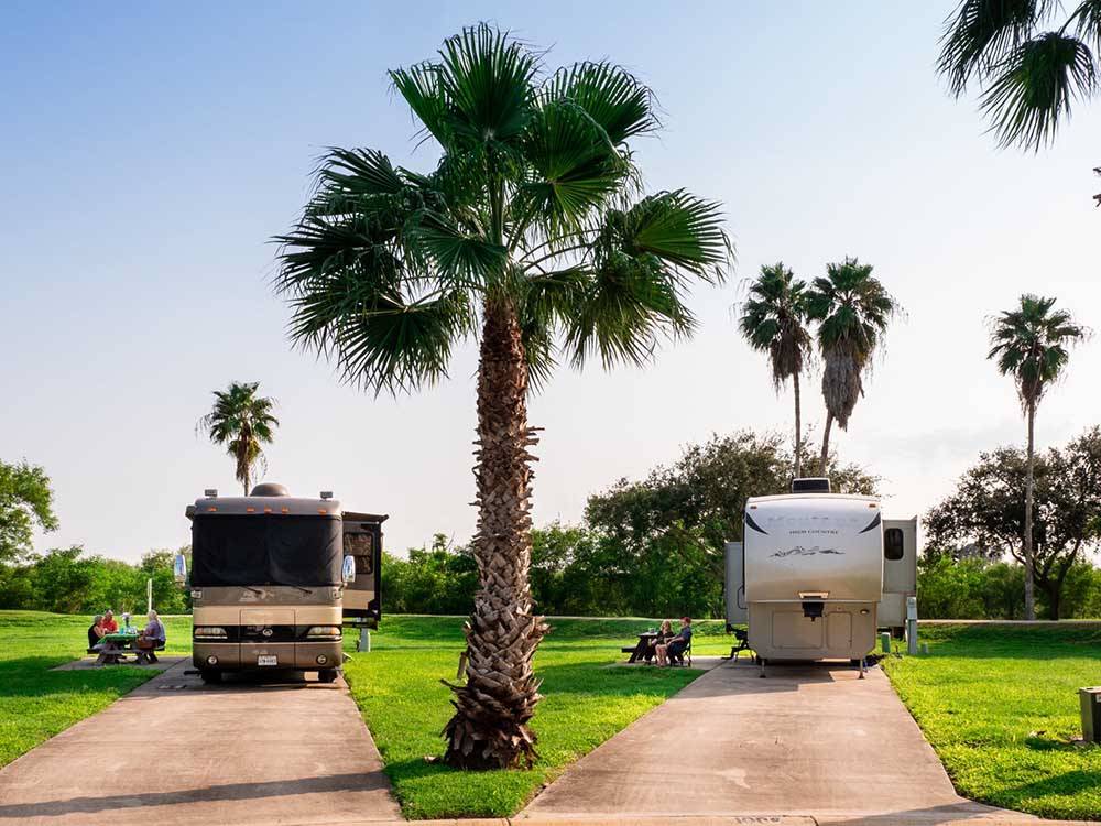 A motorhome and fifth wheel trailer parked in concrete sites at RIVER BEND RESORT & GOLF CLUB