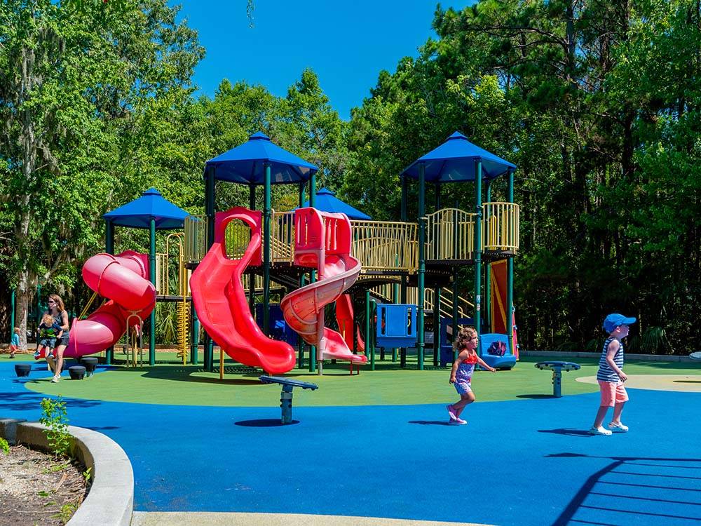 Kids cavorting in front of a colorful play structure at THE CAMPGROUND AT JAMES ISLAND COUNTY PARK