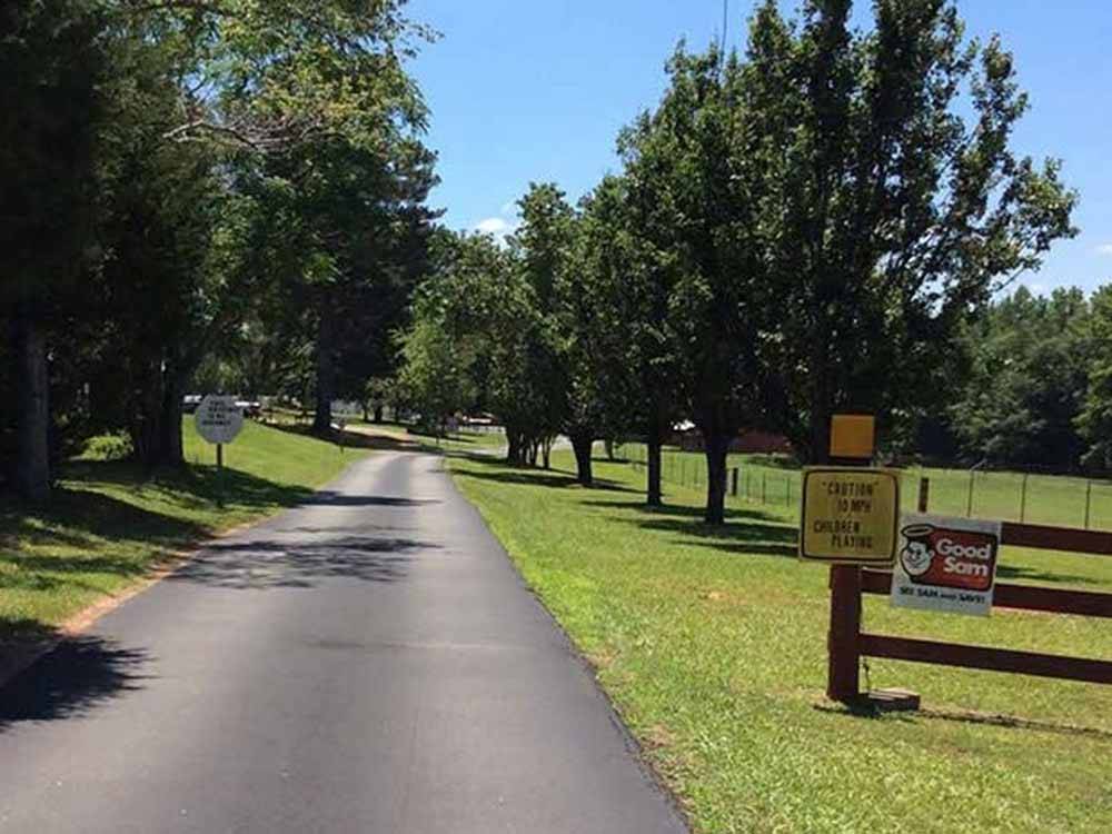 A paved road lined with trees at L & D RV PARK