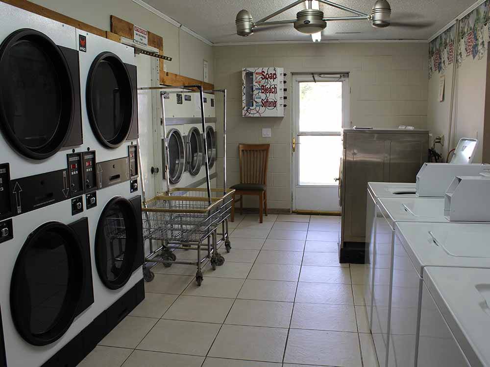 Washers, driers and rolling baskets in laundry room at TRIPLE 'J' RV PARK