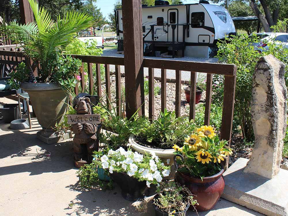 Potted flowers and welcome sign at TRIPLE 'J' RV PARK