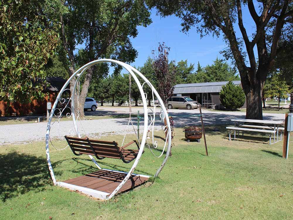 Swinging bench near a fire pit and picnic table at TRIPLE 'J' RV PARK