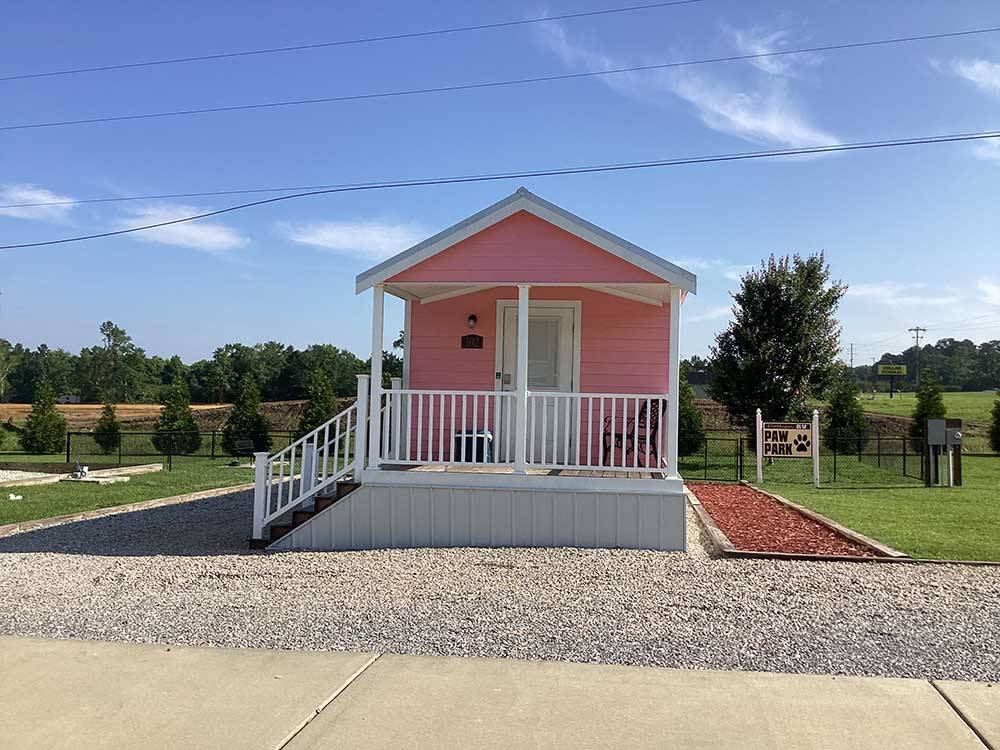 A pink cabin rental with a deck at DOTHAN RV PARK