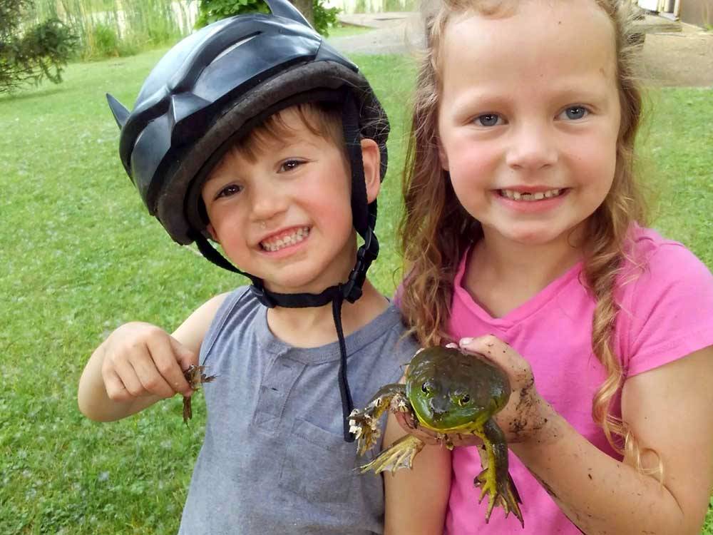 A couple of kids holding frogs at LAKE BLUFF CAMPGROUND