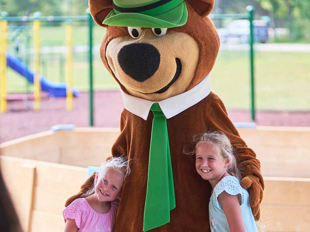 Two young girls standing with Yogi Bear at JELLYSTONE PARK AT MAMMOTH CAVE