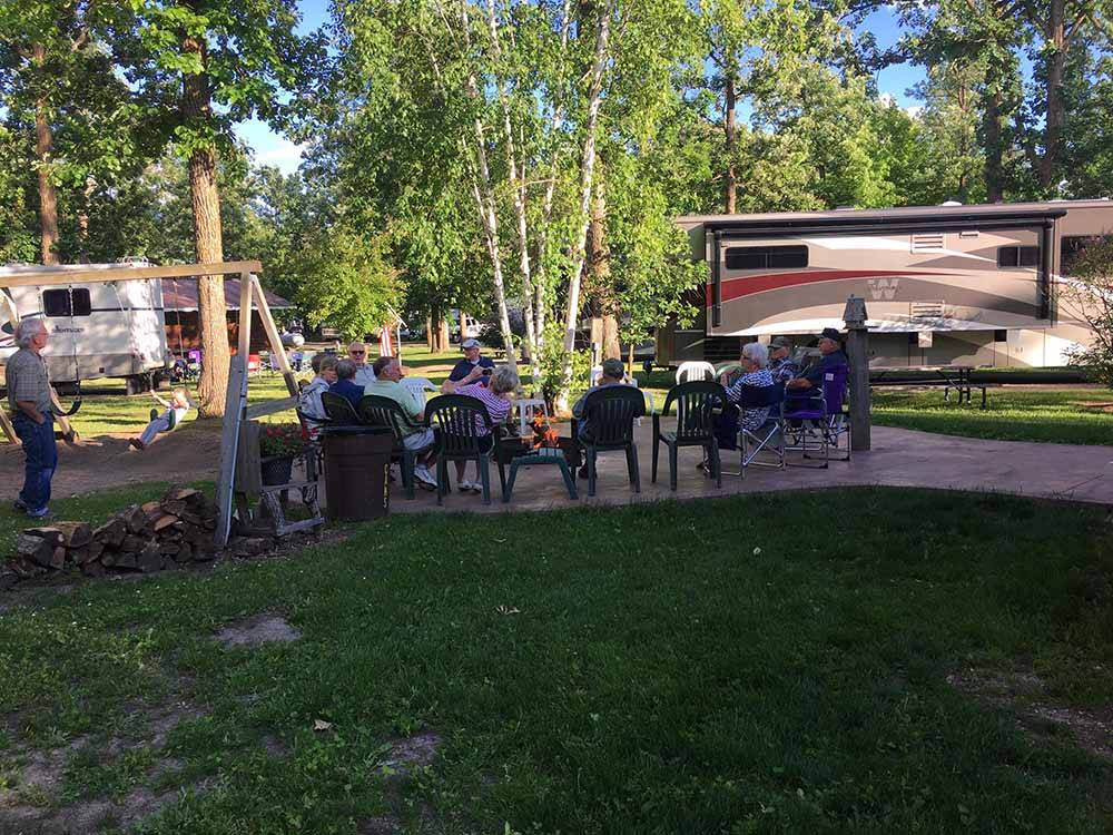 People sitting around a fire pit at ROYAL OAKS RV PARK
