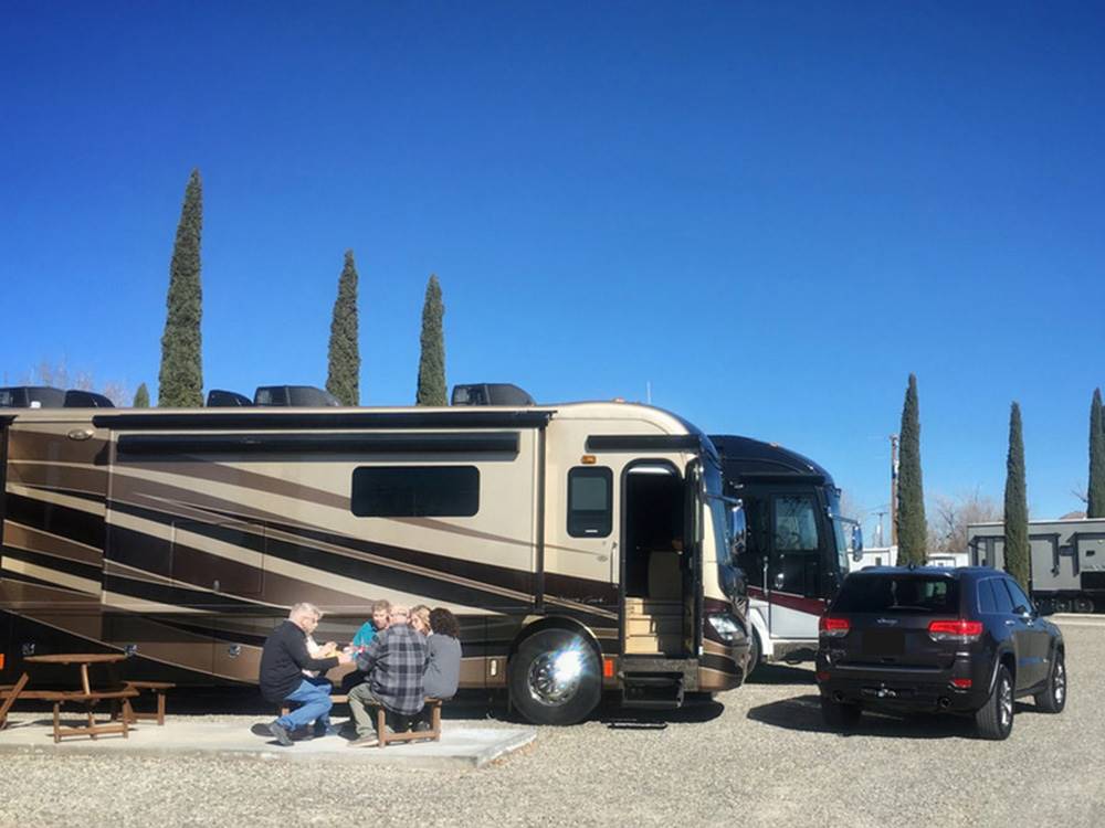 People sitting outside a parked RV at Lifestyle RV Resort