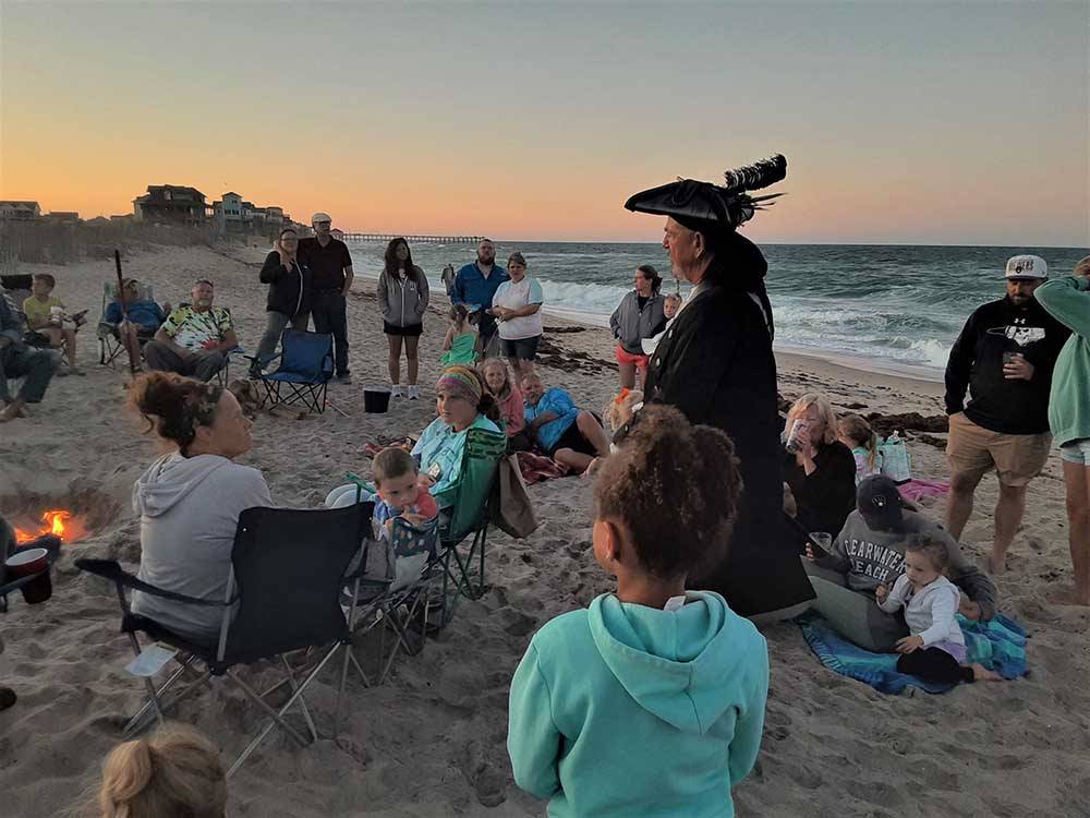 A man dressed as a pirate talking to guest on the beach at CAMP HATTERAS RV RESORT & CAMPGROUND