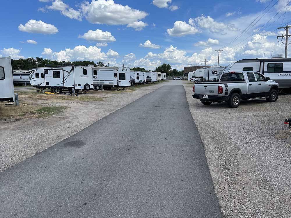 A paved road running between gravel RV sites at OVERLAND RV PARK