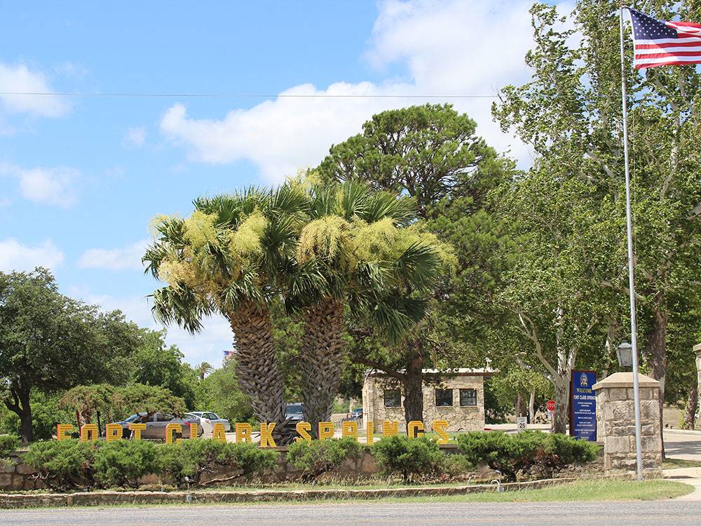 The entrance with three palm trees at FORT CLARK SPRINGS RV PARK