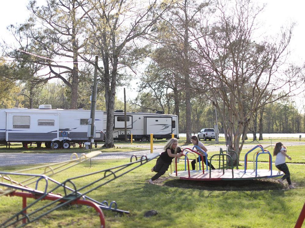 Children playing on the merry-go-round at THE OUACHITA RV PARK